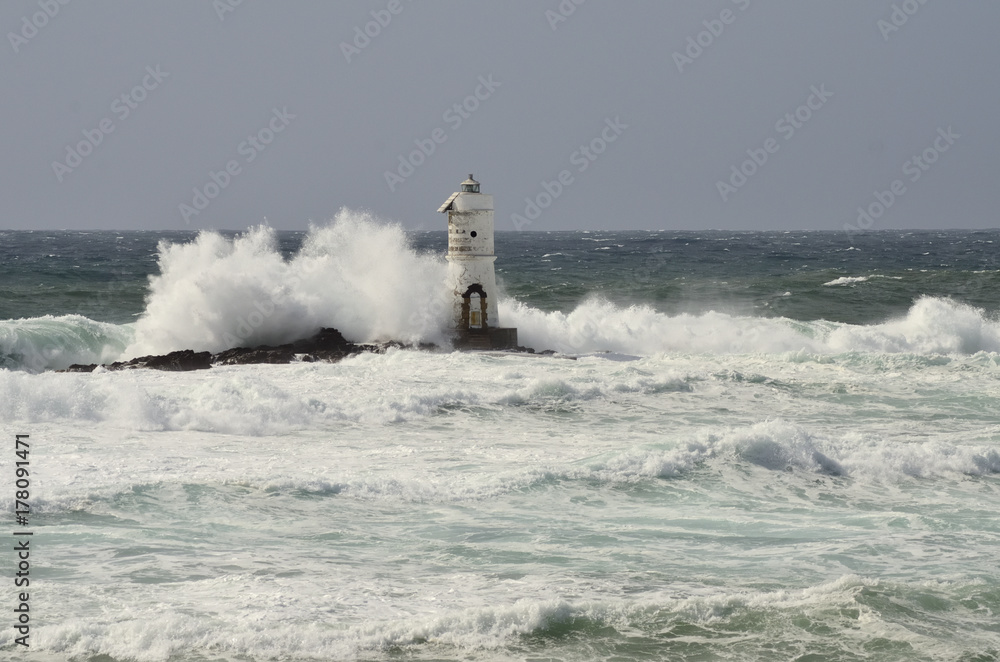 Italy, `Mangiabarche`, Storm. Waves smash against lighthouse or beacon.