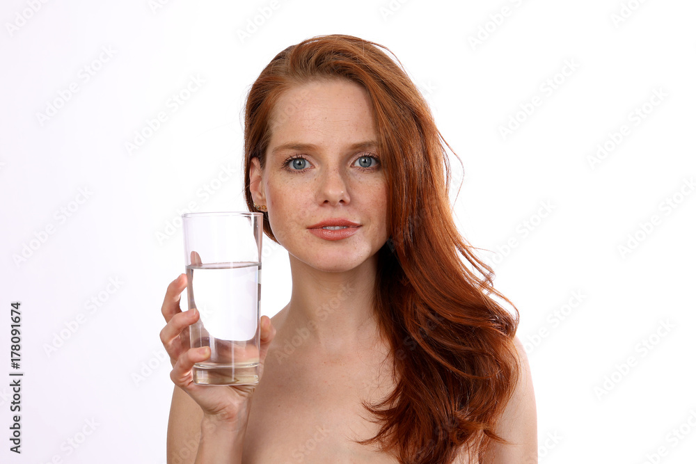 Hübsche rothaarige Frau hält ein Glas Wasser Hübsche rothaarige Frau hält ein Glas Wasser