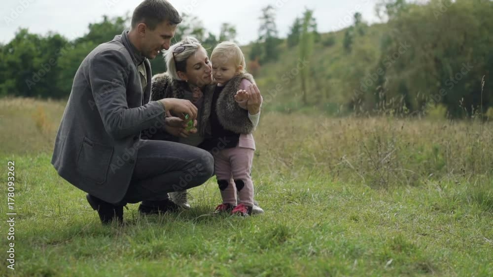 Happy family rest on the nature with kid, blowing and catching bubbles Happy family rest on the nature with kid, blowing and catching bubbles