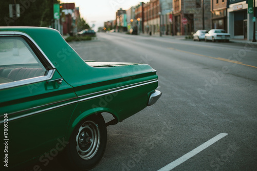 Vintage green car on city street photo