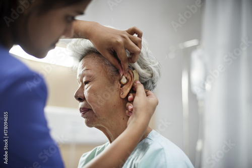 An elderly woman with hearing aid photo