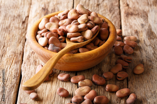Fotografie Dried organic healthy broad beans close-up in a wooden bowl