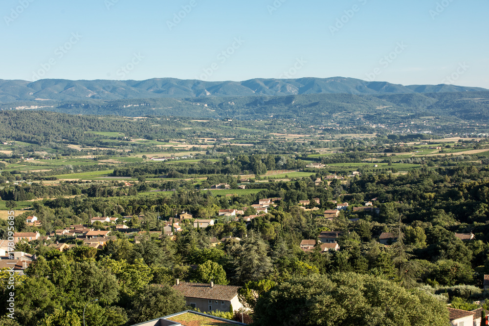 Fototapeta premium Panoramic view of cultivated fields, vineyards and mountains in Provence, France