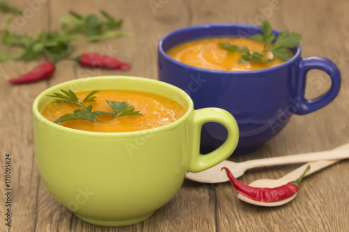 A bright cream soup of pumpkin on a wooden table.
