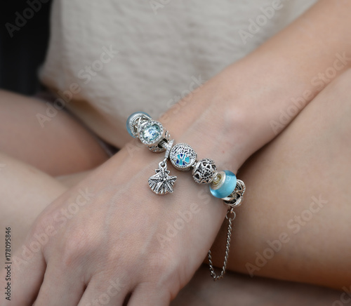Luxury silver bracelet on women wrist. Bracelet in hand on women legs