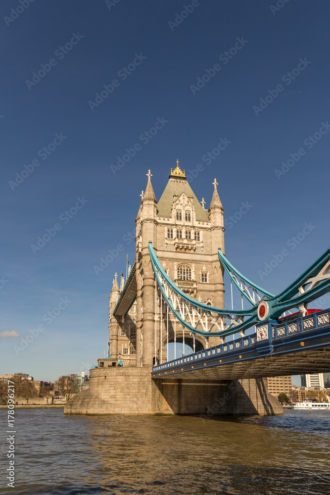Tower Bridge, vertical shot with the river and a blue sky.