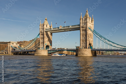Tower Bridge in London with blue sky and reflections in the river Thames.