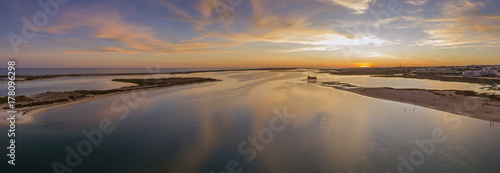 Aerial sunset and historic life-guard building at Fuseta fishing town, in Ria Formosa wetlands nature conservation park, Algarve. Portugal