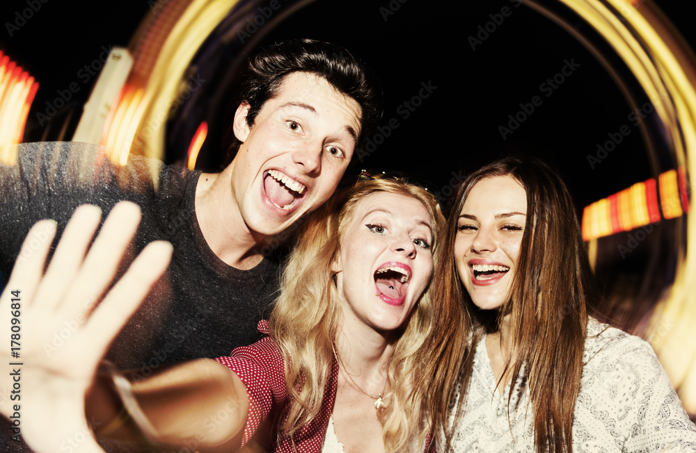 A group of friends is enjoying the amusement park A group of friends is enjoying the amusement park