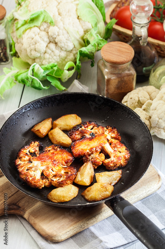 Vegetarian roasted cauliflower steak with herbsand fried potatoes