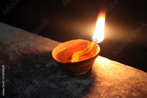 igniting soil lamp in diwali festival