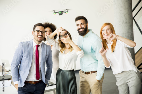 Business people letting the drone camera to fly over the office and having fun