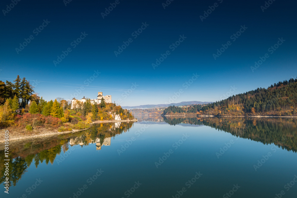 Panoramic image over lake with Nidzica castle at autumn