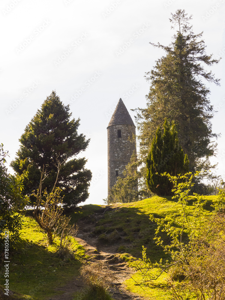 The ancient round tower in the cemetery at the historic Glendalough Monastic Site in County Wicklow in Ireland