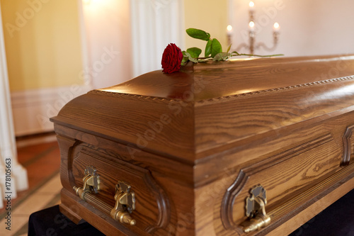 red rose flower on wooden coffin in church photo