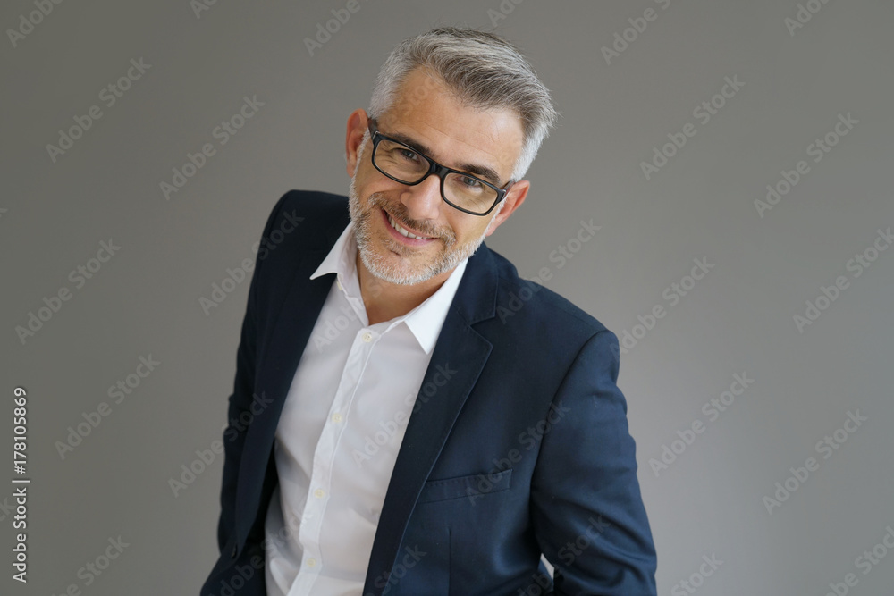 Portrait of businessman standing on grey background, isolated Portrait of businessman standing on grey background, isolated