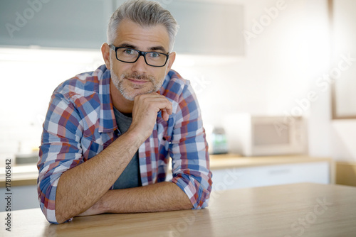 Middle-aged man with grey hair in home kitchen
