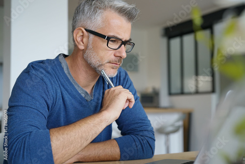 Middle-aged man working from home-office on laptop