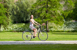 happy woman riding fixie bicycle in summer park