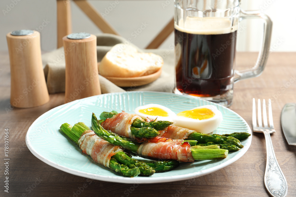 Plate with bacon wrapped asparagus on table Plate with bacon wrapped asparagus on table
