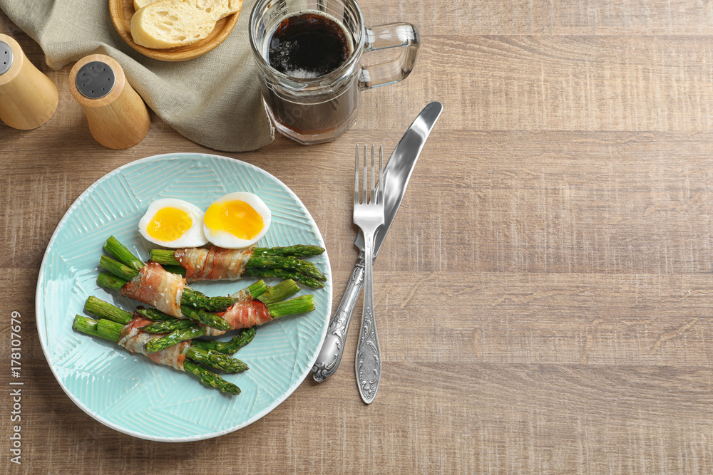 Plate with bacon wrapped asparagus on table Plate with bacon wrapped asparagus on table