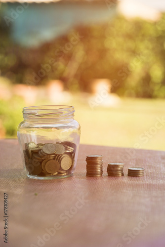 A transparent jar with many coins saved photo