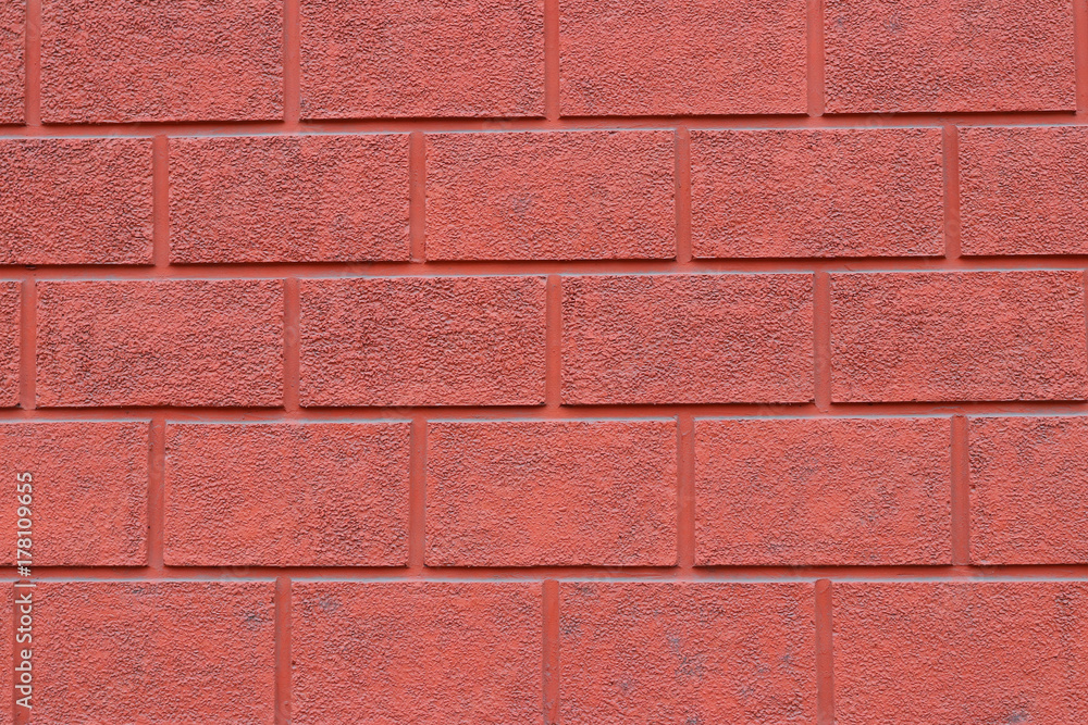 Red wall finished with plaster with imitation of brickwork Red wall finished with plaster with imitation of brickwork