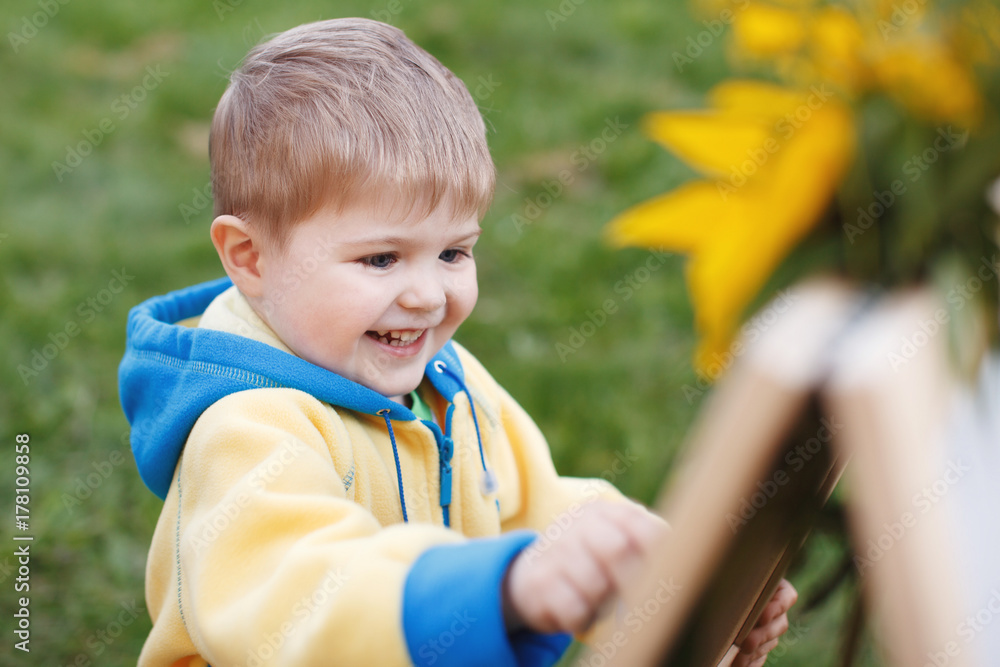 Little baby boy with blue eyes and blond hairs close up outdoors in park Little baby boy with blue eyes and blond hairs close up outdoors in park