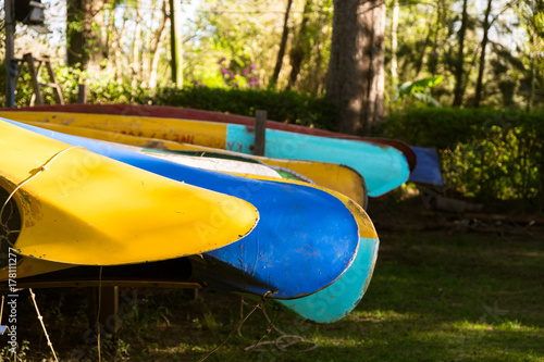 Canoes lined up in the warm evening light, ready to be taken on the water