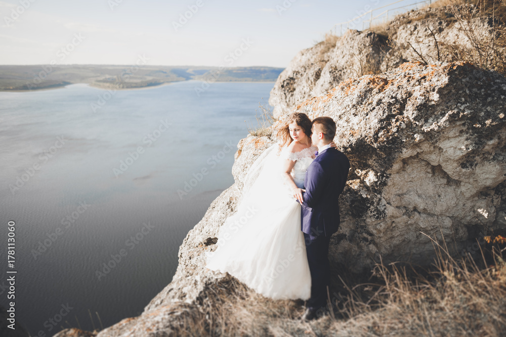 Happy wedding couple staying over beautiful landscape Happy wedding couple staying over beautiful landscape