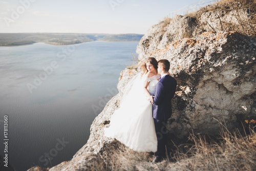 Happy wedding couple staying over beautiful landscape