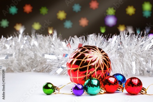 Christmas decorations and silver defocused tinsel on a dark background with blurred lights