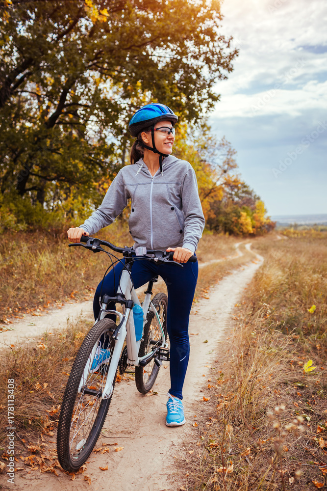 Young woman riding a bicycle in the autumn field Young woman riding a bicycle in the autumn field