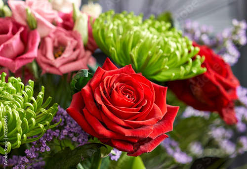 A closeup of a bouquet of flowers including a red rose.