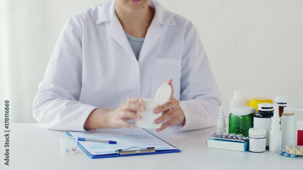 doctor putting pills into medicine cup at hospital doctor putting pills into medicine cup at hospital