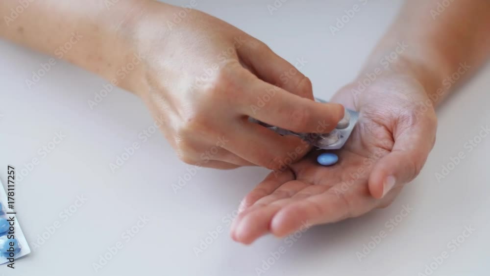woman hands opening pack of medicine pills woman hands opening pack of medicine pills