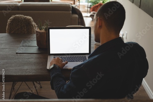 Man using laptop at home photo