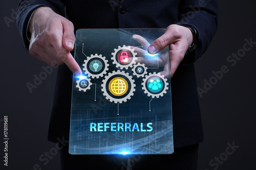 Business, Technology, Internet and network concept. Young businessman working on a virtual screen of the future and sees the inscription: Referrals