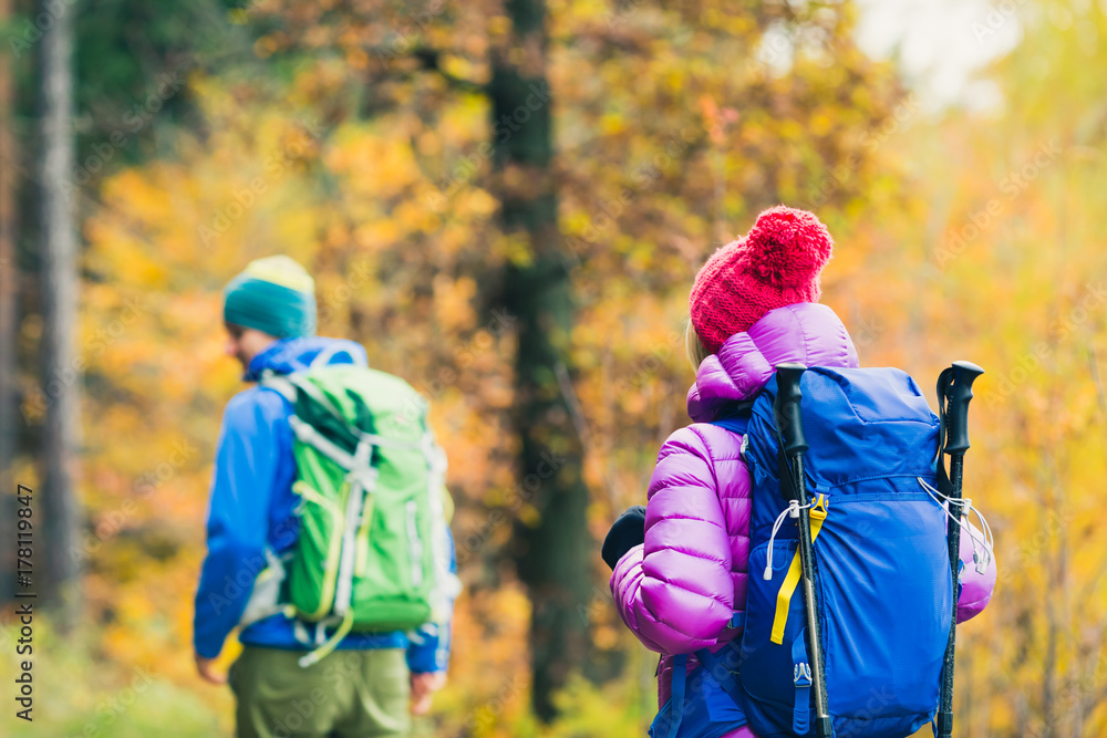 Man and woman happy couple hikers walking in autumn woods Man and woman happy couple hikers walking in autumn woods