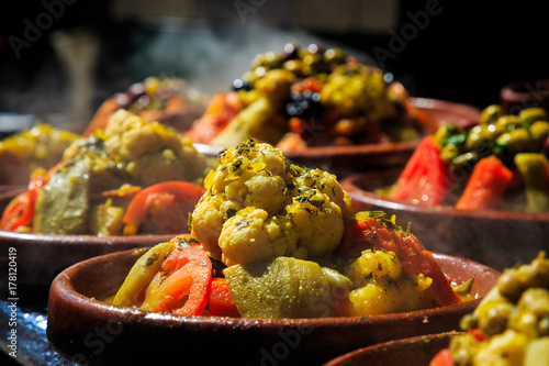 A lot of warm tagines with delicious vegetables on a market