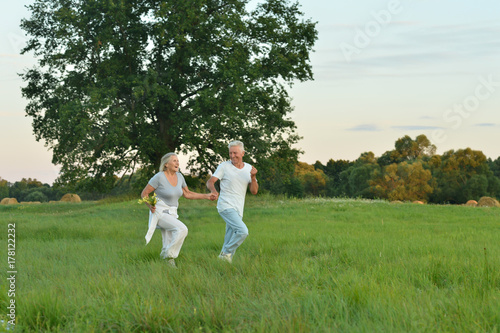  senior couple running in field