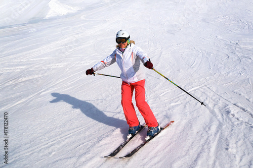 Middle aged woman alpine skiing in the snow in winter.
