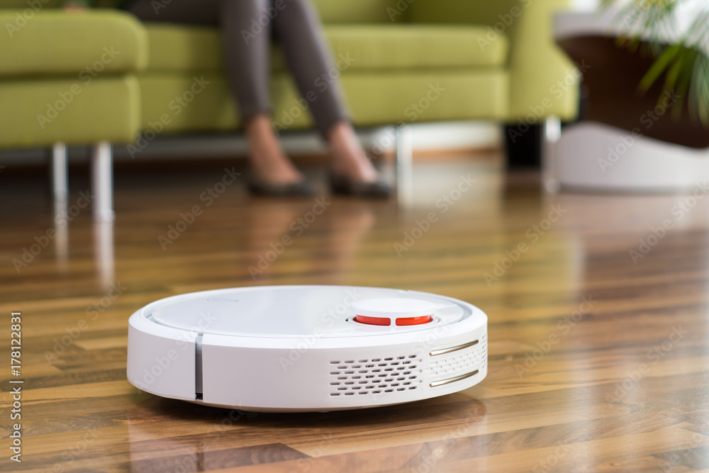 Saugroboter / Staubsaugerroboter reinigt Wohnung - Frau kann sich entspannen Saugroboter / Staubsaugerroboter reinigt Wohnung - Frau kann sich entspannen