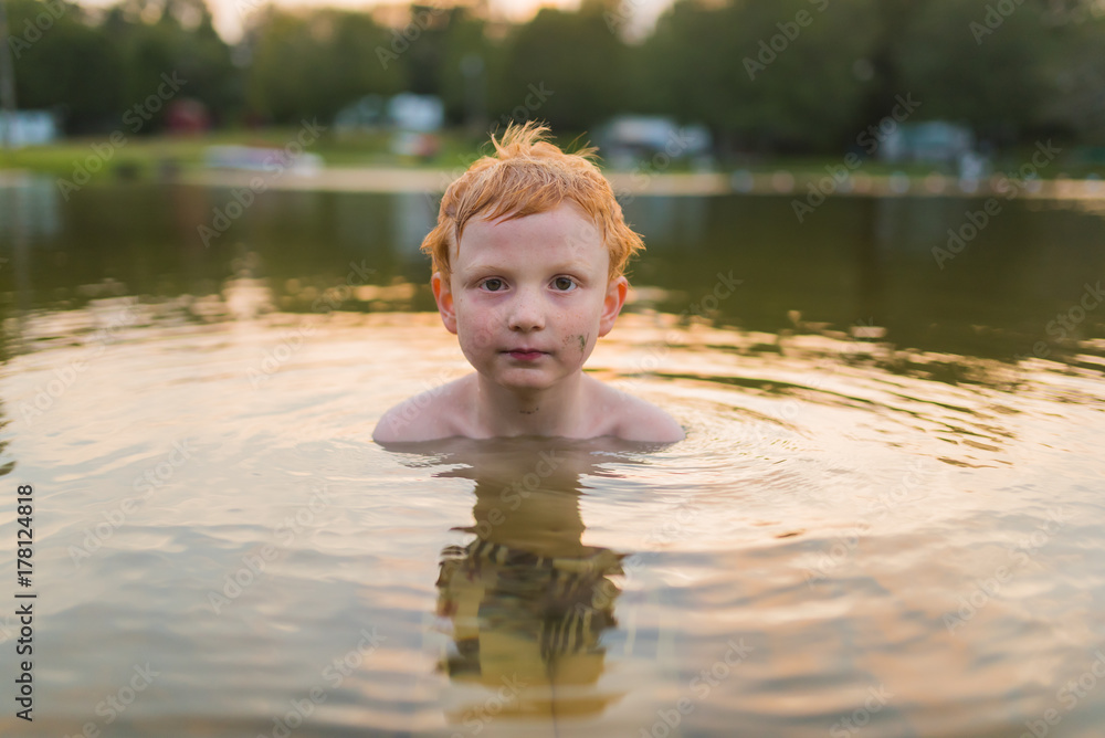 Fototapeta premium Boy swimming at sunset