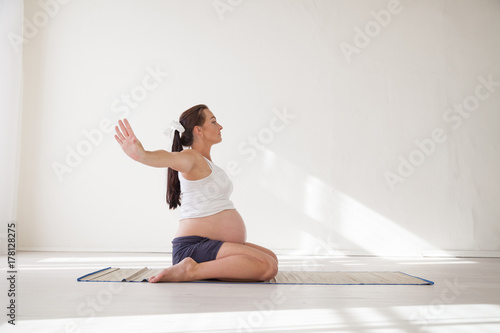 a pregnant woman is engaged in gymnastics and yoga photo