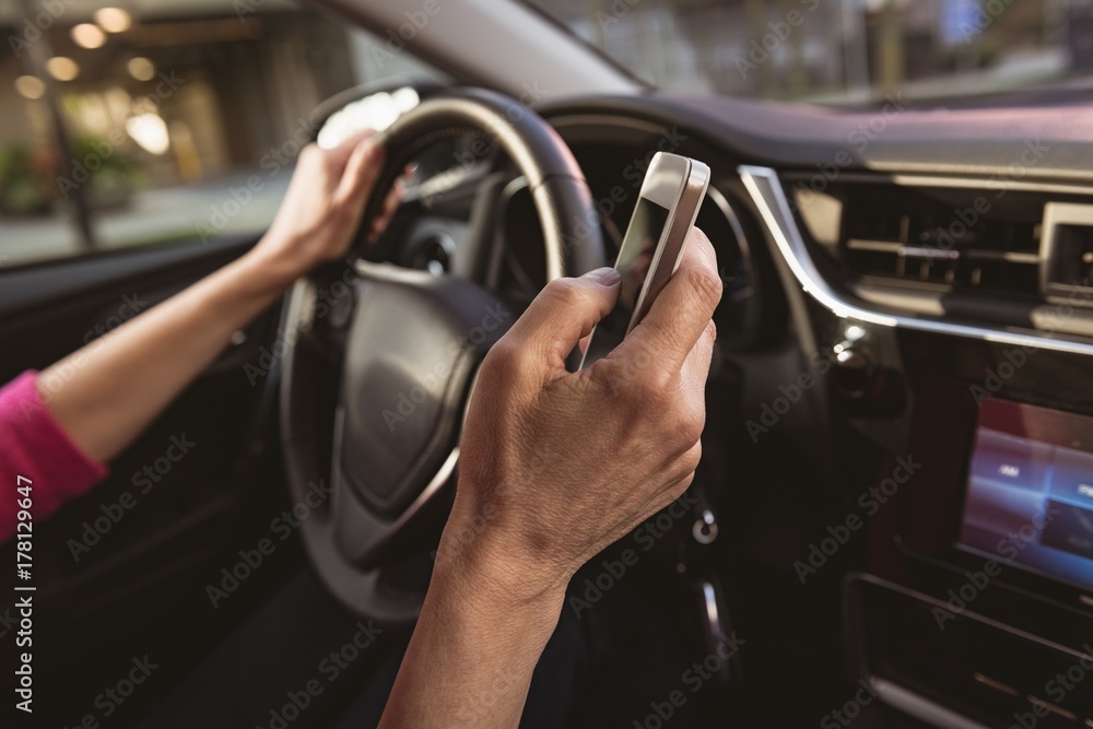 Woman using mobile phone while driving car Woman using mobile phone while driving car