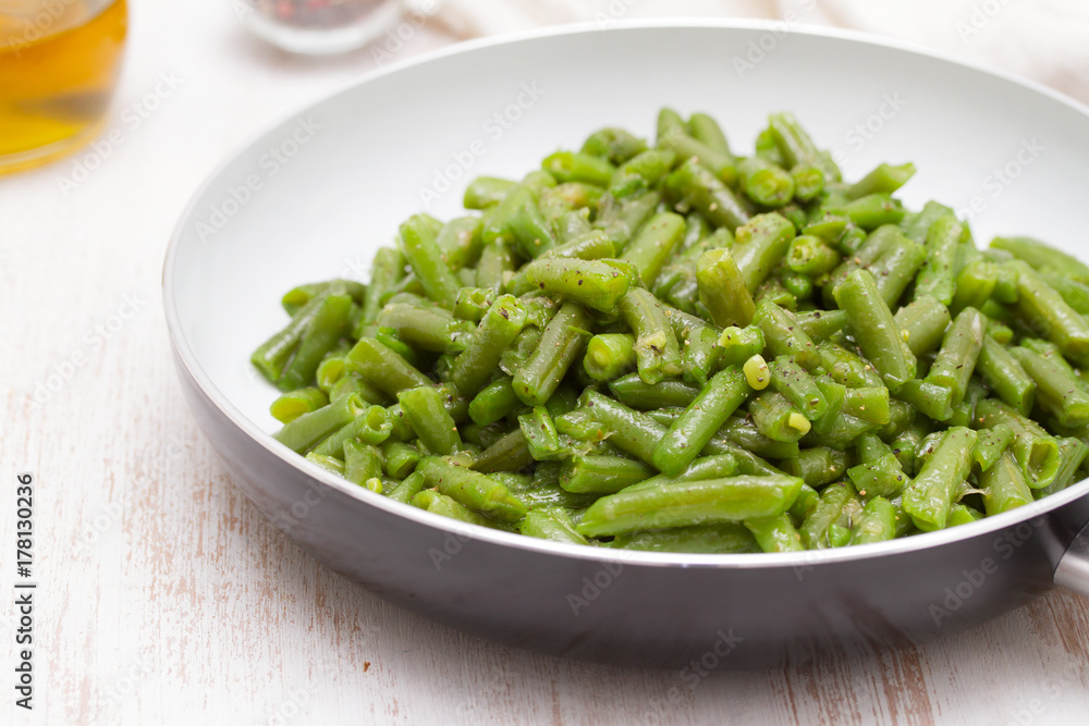 green beans on frying pan on wooden background green beans on frying pan on wooden background