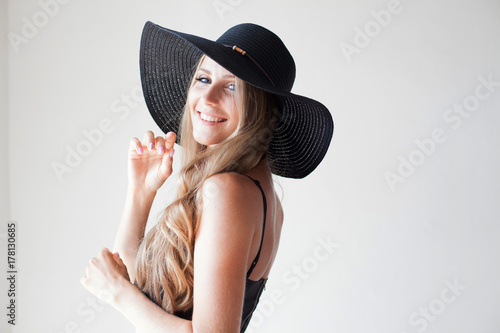 fashionable girl in a hat with a brim poses for advertising photo