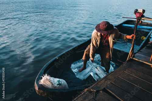 a man delivery ice blocks by boat