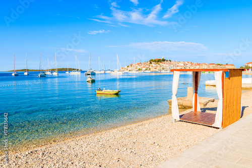Sunbed on beautiful beach with crystal clear turquoise water in Primosten town, Dalmatia, Croatia